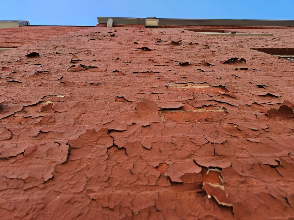 Close-up of deteriorating Paint and Mortar Joints on brick wall