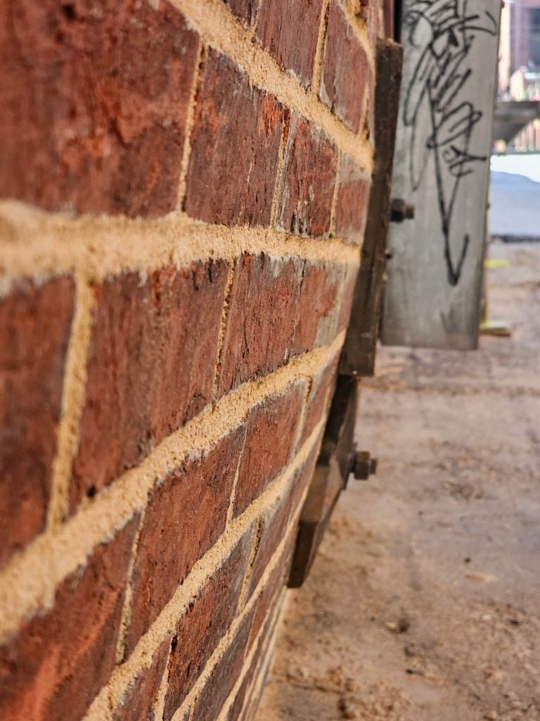 Close-up view of cracks in masonry facade due to lateral pressure