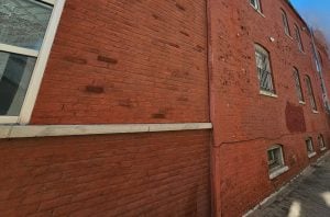 Close-up view of deteriorating paint on exterior masonry wall
