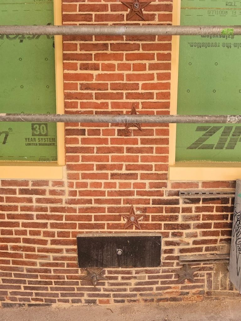 Engineers inspecting structural movement in a masonry facade wall
