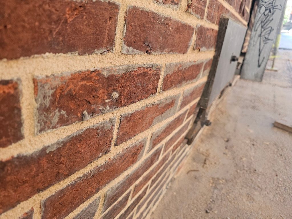 Severe Lateral Deflection in a Masonry Facade - Part III 3 Engineers inspecting a leaning masonry facade structure
