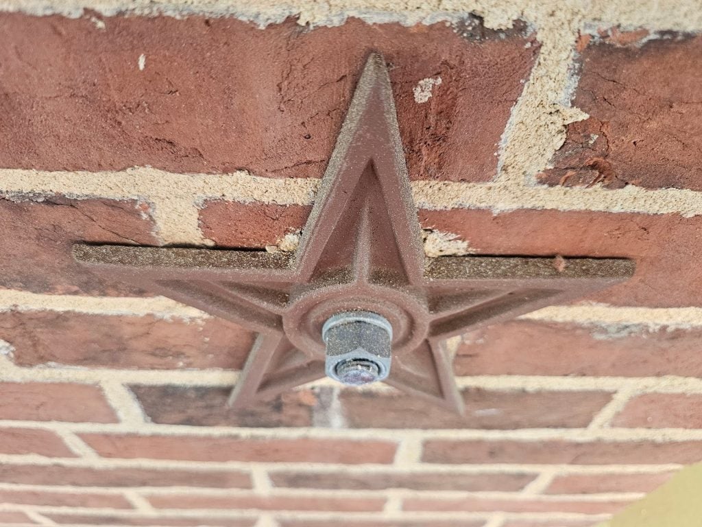 Engineers inspecting structural movement in a masonry facade wall