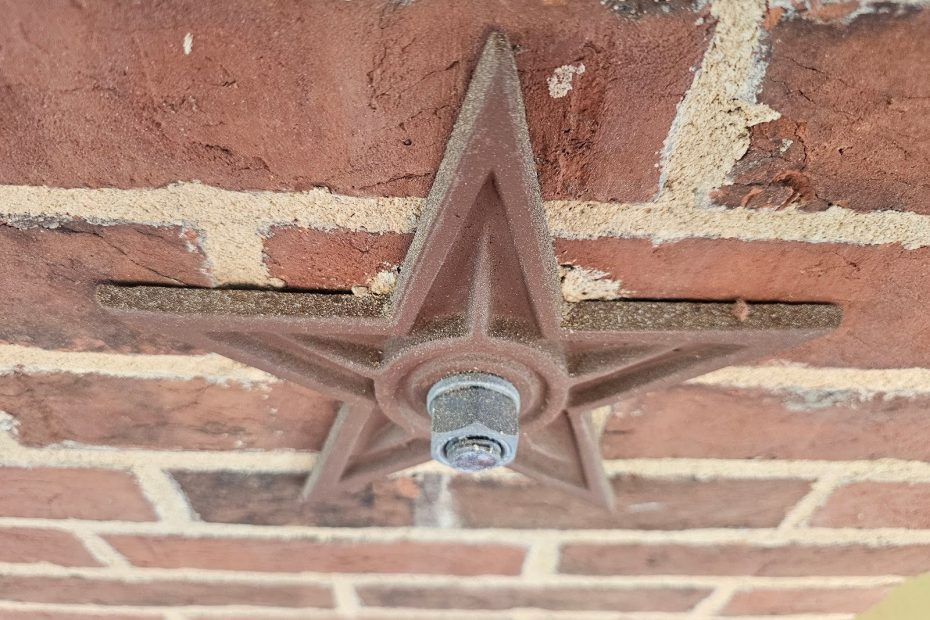 Engineers inspecting structural movement in a masonry facade wall