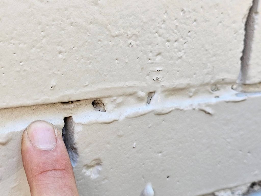 jammed into spaces between bricks