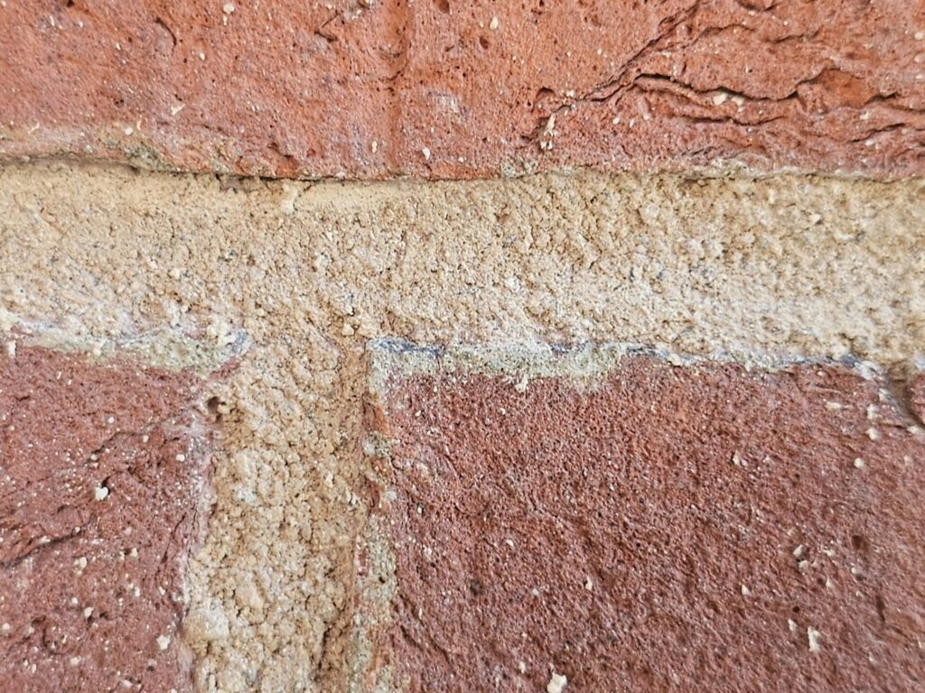 Historic brick wall preservation project with fresh mortar and repaired joints