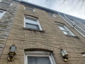 Historic brick wall covered with Formstone veneer on a Washington, DC rowhouse before restoration